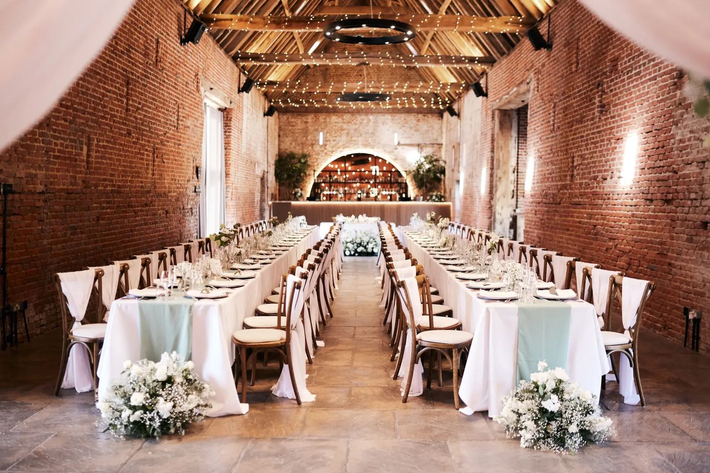 Long tables dressed with table settings and flowers at Copdock Hall