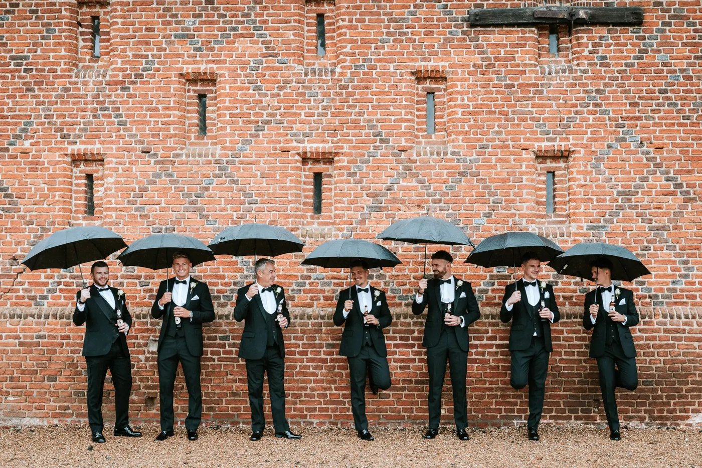 Groomsmen posting with umbrellas at Copdock Hall