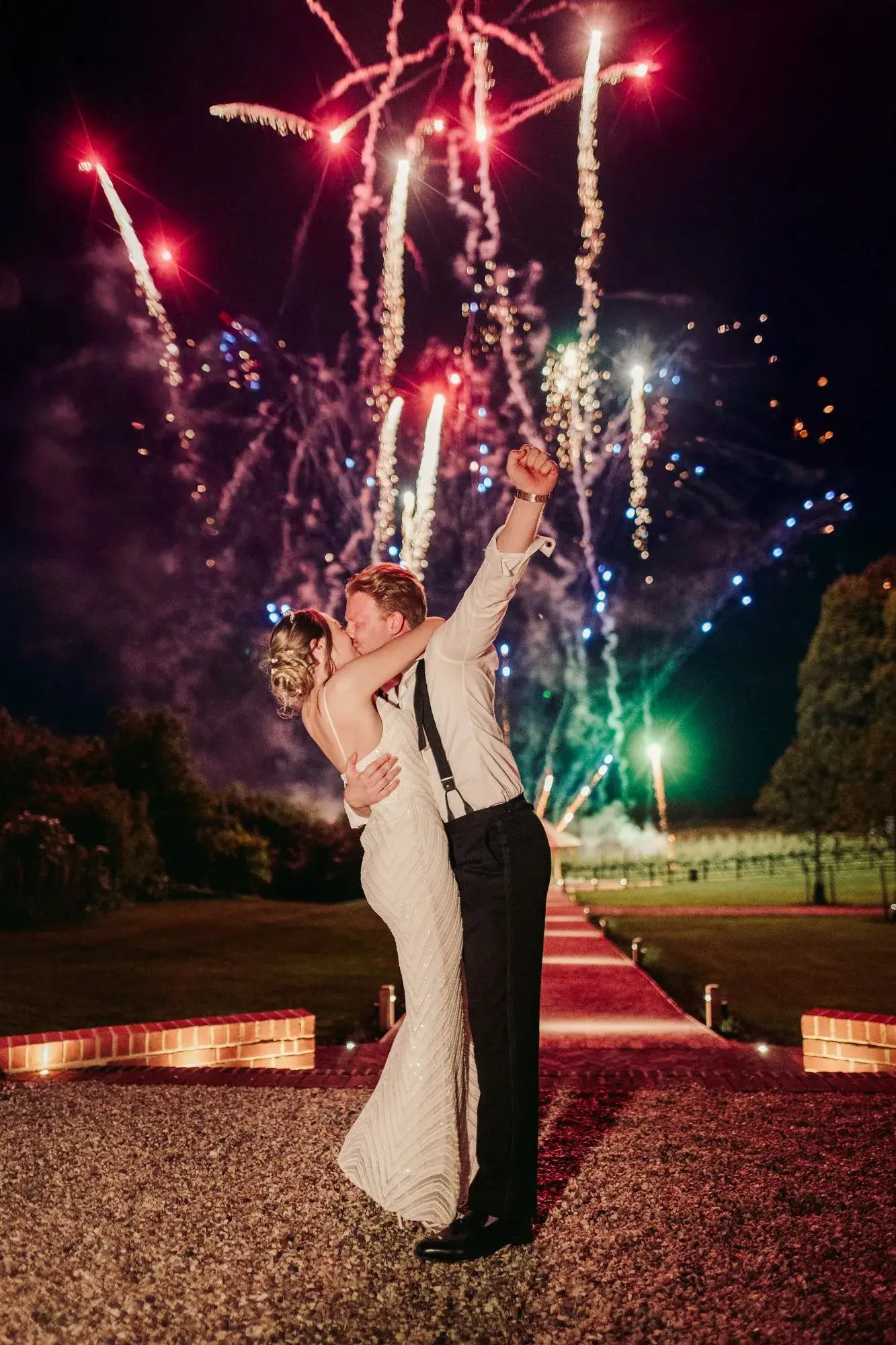 Couple kissing with fireworks in the background at Copdock Hall