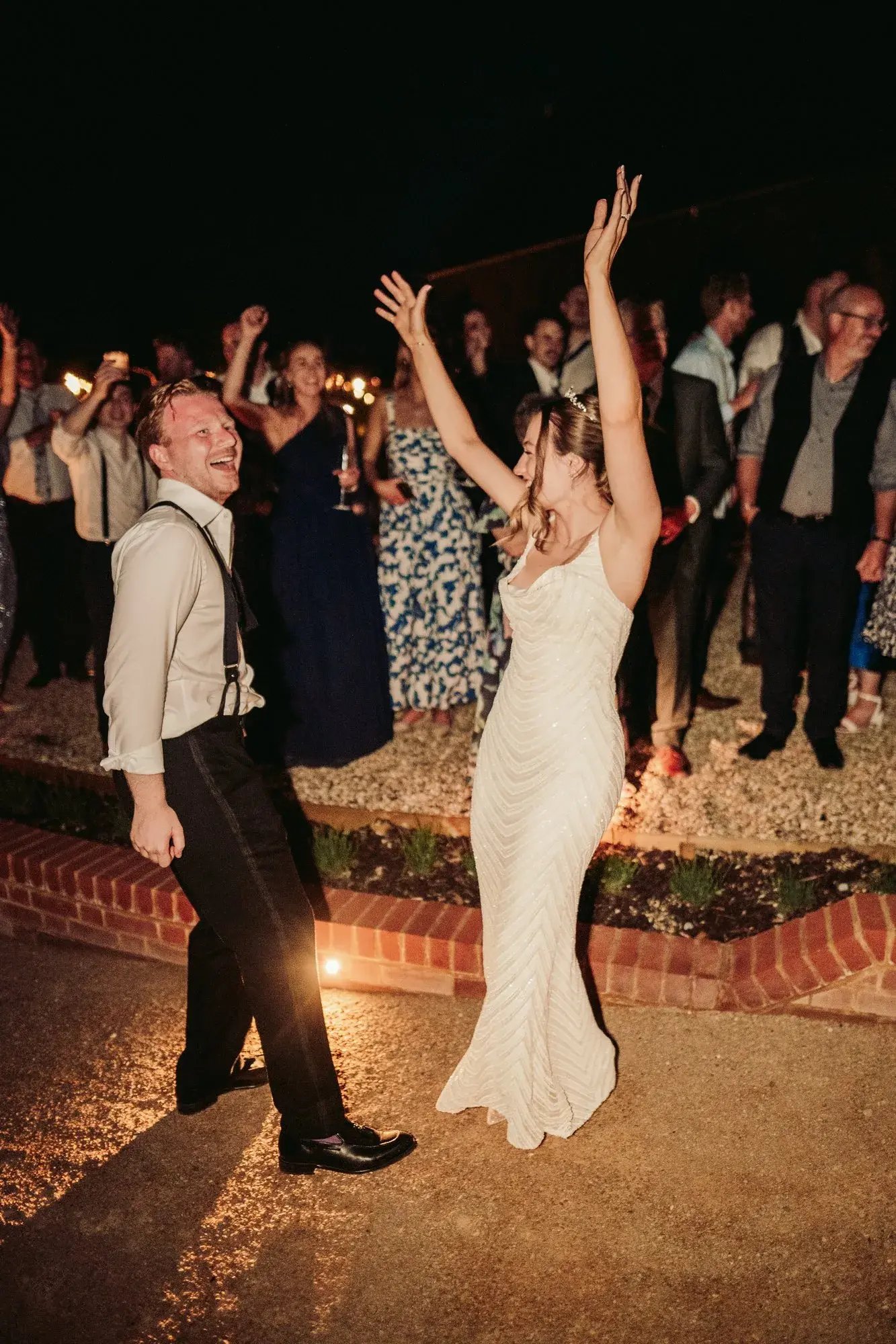 Couple celebrating in the courtyard during the night at Copdock Hall