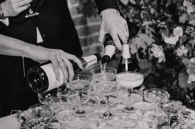 Couple pouring Champagne in the barn at Copdock Hall