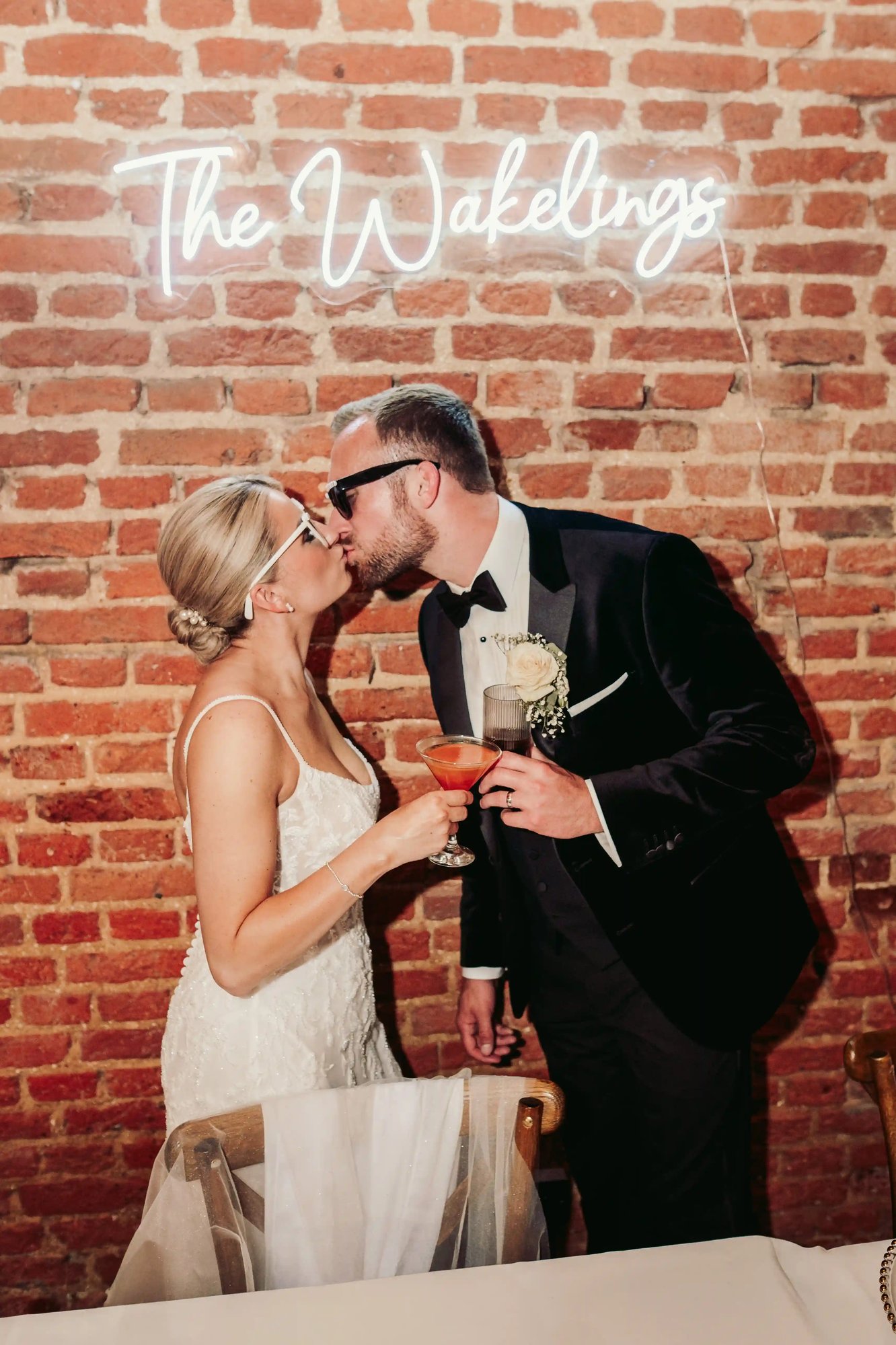 Couple kissing under neon sign at Copdock Hall