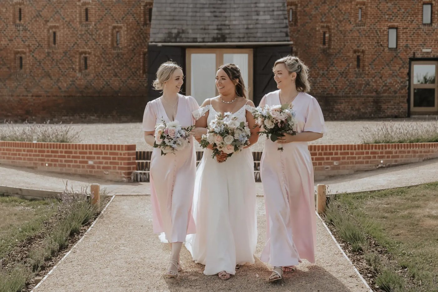 Bride and bridesmaids walking in the grounds at Copdock Hall