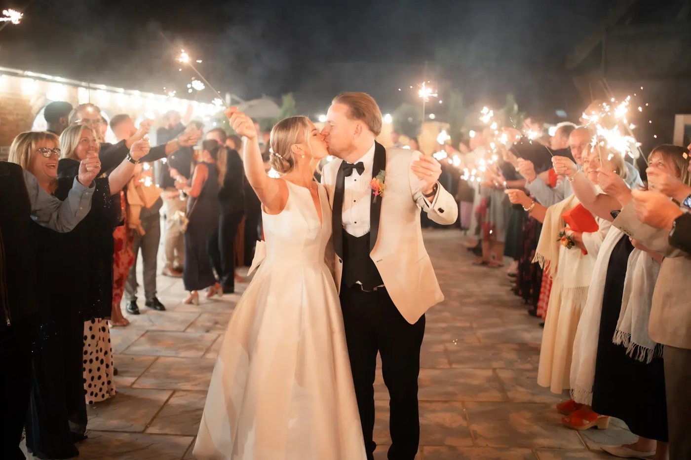 Couple posing with sparklers in the courtyard at Copdock Hall
