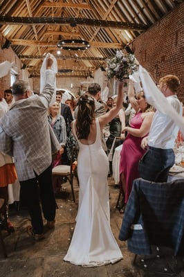 Bride and groom entering the barn for wedding breakfast at Copdock Hall