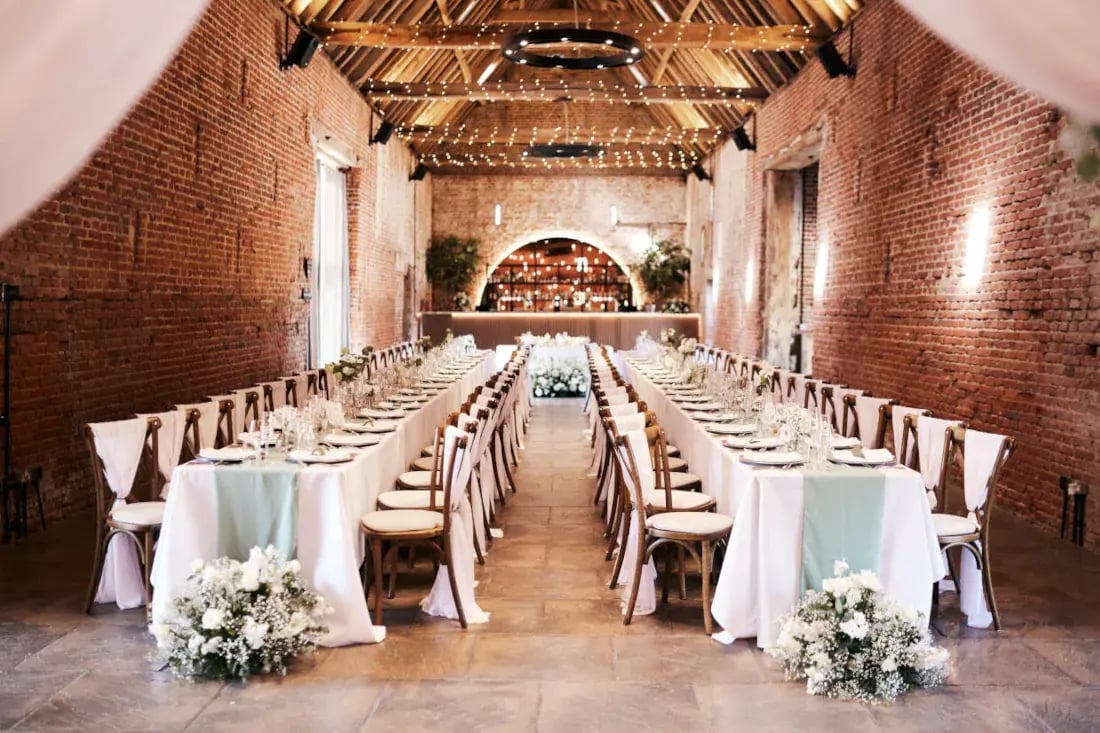 Copdock hall wedding breakfast set up with long tables and white florals