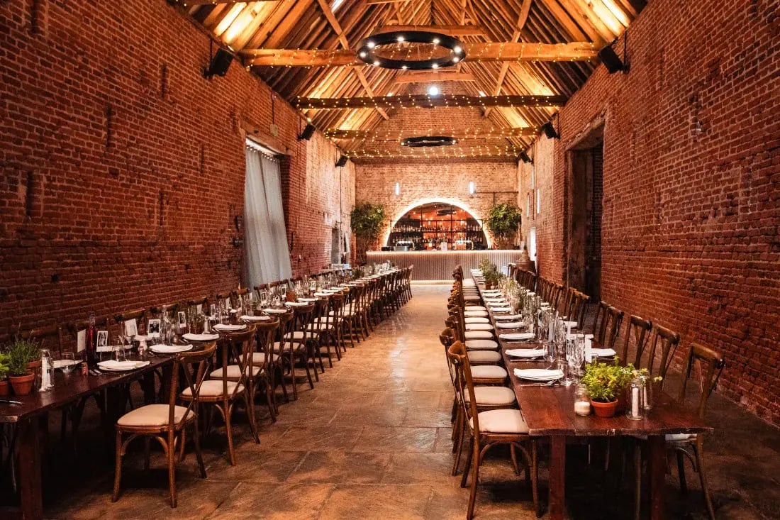 Copdock hall long tables set up in barn with nature inspired table centrepieces